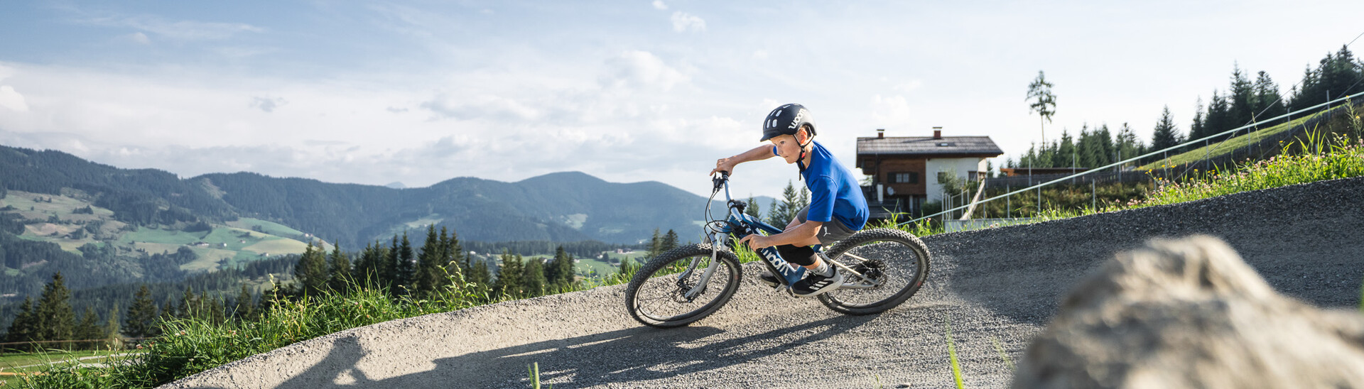 Kind auf einem Fahrrad bei einer Fahrt in der woom bike area von Snow Space Salzburg